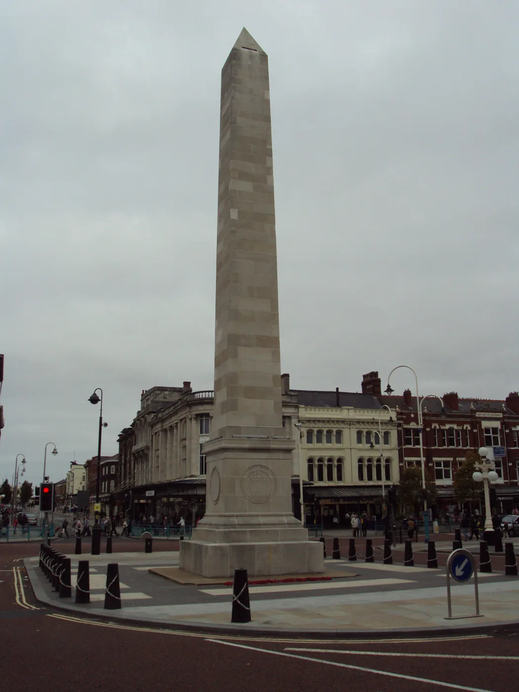 The Southport war memorial on Lord Street, the obelisk known locally as The Monument, with poppy wreaths laid at its base. The parade ends here.